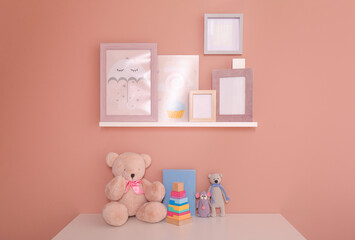 Book with toys on table and pictures near beige wall. Interior design