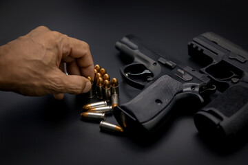 Short pistol with ammunition placed on a dark black background.	