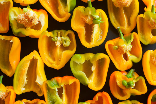 Background Of Cut Bell Peppers On A Black Background, Yellow Vegetable.