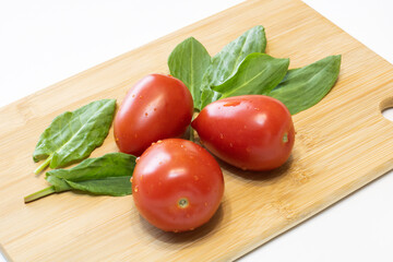 Tomatoes and sorrel on a wooden cutting board