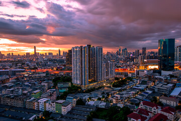 Obraz premium The high angle background of the city view with the secret light of the evening, blurring of night lights, showing the distribution of condominiums, dense homes in the capital community