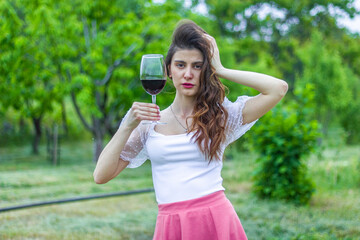 woman with wine, woman with glass of wine, woman drinking red wine in the garden