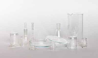 A set of glass chemical glassware on light laboratory table. Science, education and research concept. Composition from laboratory glassware. High key. Chemical background. Focus on the petri dish