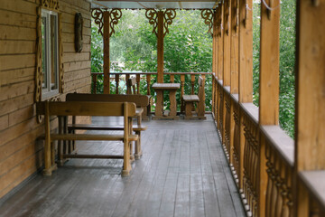 Recreation and dinner area on the veranda of a large wooden country house in Russian style. Wooden hotel house