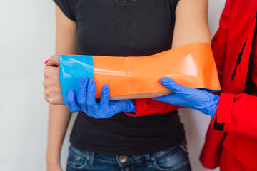 Close-up of Female Broken Arm in Plaster Cast. Caucasian Injured Woman in black T-Shirt Sitting and...