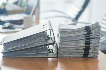 Paper documents stacked on wooden desk at workplace.Business Concept.