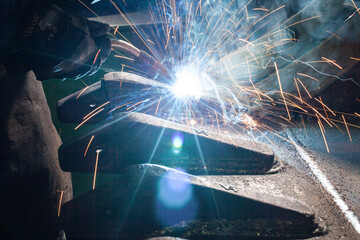 steel worker welding at construction machine excavator