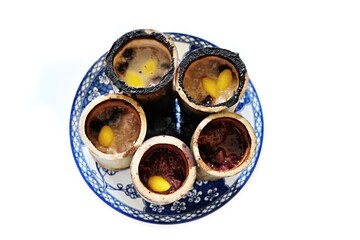 Sticky rice with coconut and taro steamed inside a piece of bamboo on plate, blurred and isolated on white background