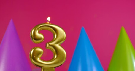 Burning birthday cake candle number 3. Happy Birthday background anniversary celebration concept. Birthday hat in the background