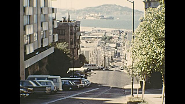 1970s archival of Alcatraz island in San Francisco Bay skyline, top of Taylor St view of Fisherman's Wharf and Pier 45. Old California of United States in 1976.