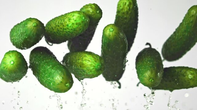 Super slow motion fresh cucumbers. On a white background.Filmed on a high-speed camera at 1000 fps. High quality FullHD footage