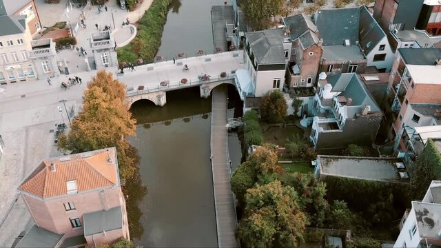 Beautiful Mechelen city centre. Wooden pier and pedestrian bridge. Aerial tilt up shot