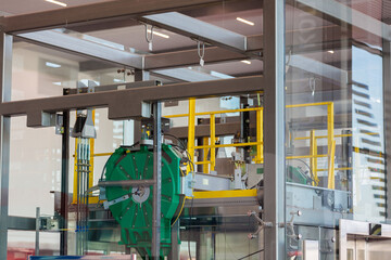 Mechanisms and details of the glass elevator at the airport. View through glass.