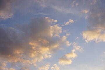 Blue sky with sunny grey golden clouds at sunset