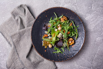 Healthy vegetarian salad with mix of fresh green leaves, blue cheese and nuts