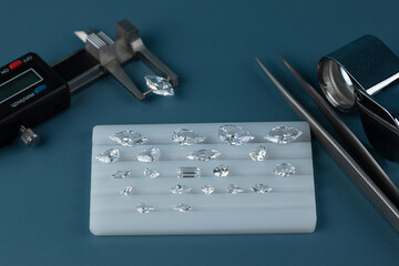 Diamonds of different sizes at the workplace of diamond dealer evaluating polished diamonds. High...
