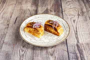 Toasted brioche bread stuffed with Spanish-style pork cheek meat and on top, little pieces of purple onion