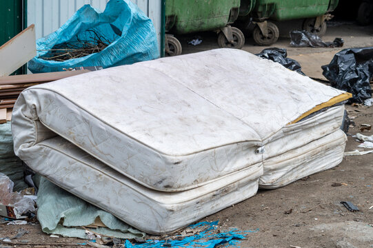 old mattress thrown in the trash