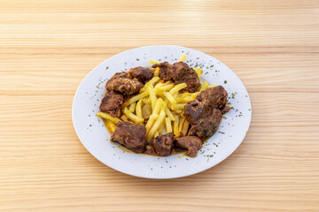 Plate of typical Spanish stewed cheek combined with a portion of chips and sauce