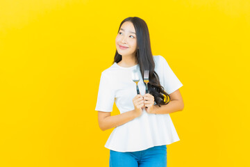 Portrait beautiful young asian woman smile with spoon and fork