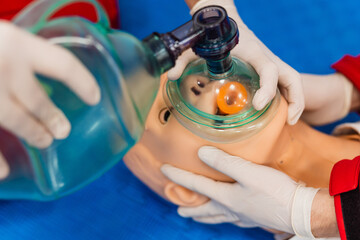 Hands holding a ambu bag on dummy patient, first aid training, CPR medical procedure