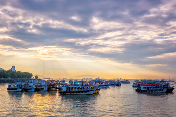 Tourist boats in sea on sunrise in Mumbai, India