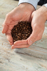 Closeup of a man holding coffe beans, selective focus
