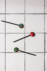 Three black teaspoons filled with colourful candy sprinkles and hundreds and thousands and a...