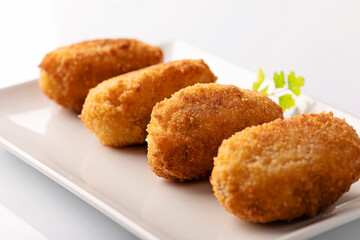 Tapa of croquetas, typical spanish dish, on white background