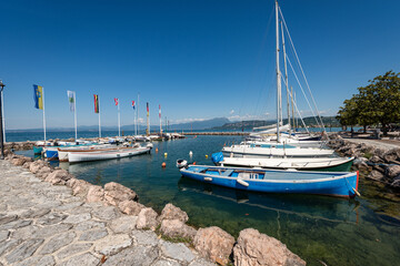Port of the small village of Cisano, tourist resort on the coast of Lake Garda (Lago di Garda). Bardolino municipality, Verona province, Veneto, Italy, southern Europe. Lombardy coast on the horizon.