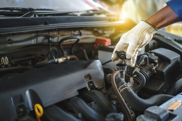 Mechanic checks the water level in the radiator in the car. He is working in a garage. Maintenance concept.