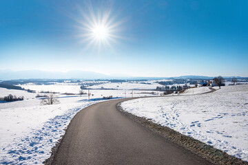 Fototapeta na wymiar curvy walkway near Riegsee, winter landscape upper bavaria with mountain view