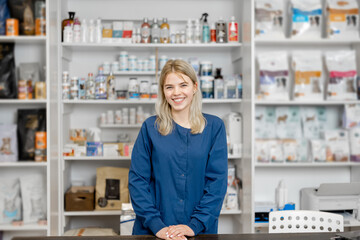 A portrait of cheerful female veterinarian staying on reception of veterinary store and clinic. Pet care and treatment.