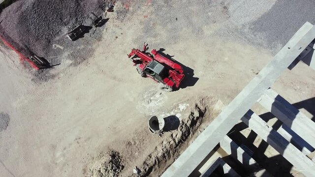 Top view of reinforced concrete structure and wheel loader. Front Loader on Construction Site, preparing to change the nozzle for work. Bulldozer works on construction site, aerial or top view.
