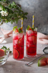 Delicious summer fruit cocktail lemonade drink with lime and mint.