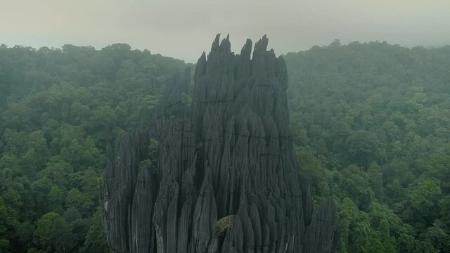Huge rock monolith on the forests of Yana village, in Karnataka, India, under fog. Drone aerial view