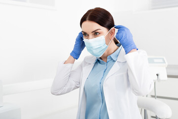 Fototapeta na wymiar dentist in latex gloves wearing medical mask in dental clinic.