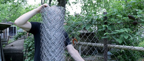 unwinding a large roll of metal mesh when installing a barrier, fencing an area in a garden or farm...