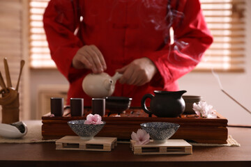 Master conducting traditional ceremony at table, focus on cups