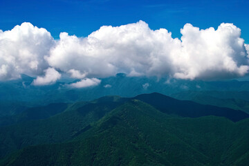 山の上に大きな雲がかかる