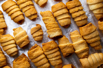 Lots of sweet home made confectionery tubes prepared to be filled with cream. Photo taken under soft artificial light.