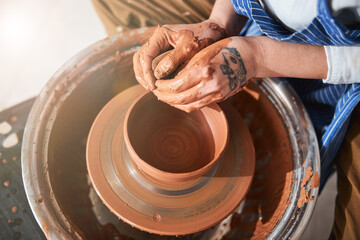 Female hands using wet sponge while shaping bowl