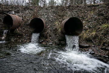 Gutter. Water runoff from a road spillway (water disposal, storm drain), two pipes and slow-flowing...