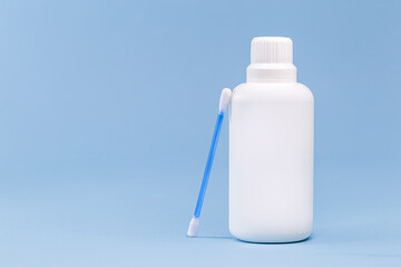 hydrogen peroxide, in white plastic bottle, with cotton swab and isolated blue background, medicine...