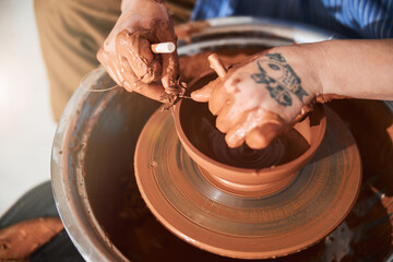Close up of master making clay utensil on pottery wheel