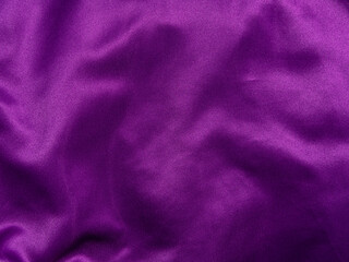 Purple silk fabric texture top view. Violet background. Fashion trendy color feminine satin dress...