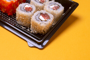 small portion of rolls with fish on an orange background