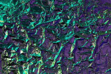 Chrome foil texture with crumpled structure effect. Green and violet fashion futuristic background with. Metallic chrome wrinkle colorful background