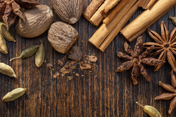 Various cooking spices, anise, cardamom, nutmeg, cinnamon on  brown table. Spices set.