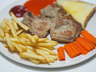 T-bone steak pork with vegetable salad, Toast and French fries on white plate food cooked for eat